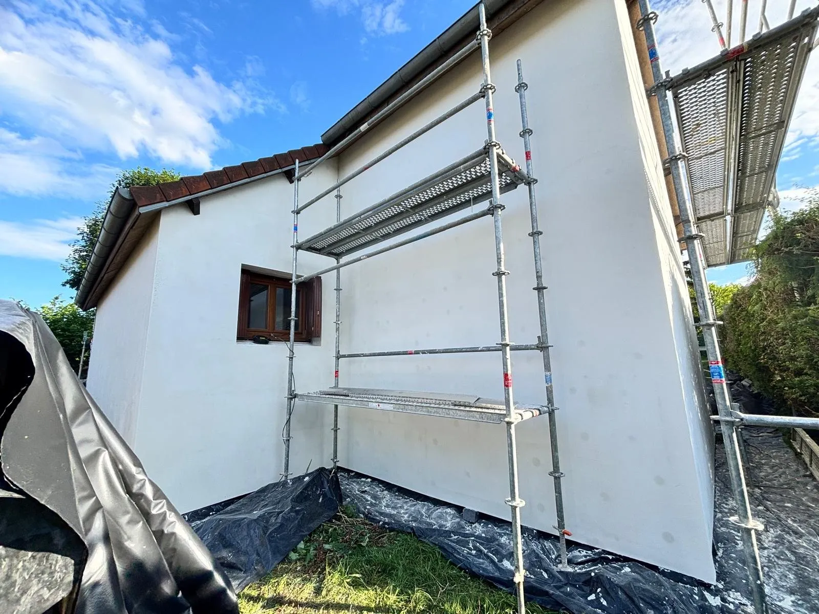 Isolation extérieure : mur enduit terminé vu depuis l'échafaudage