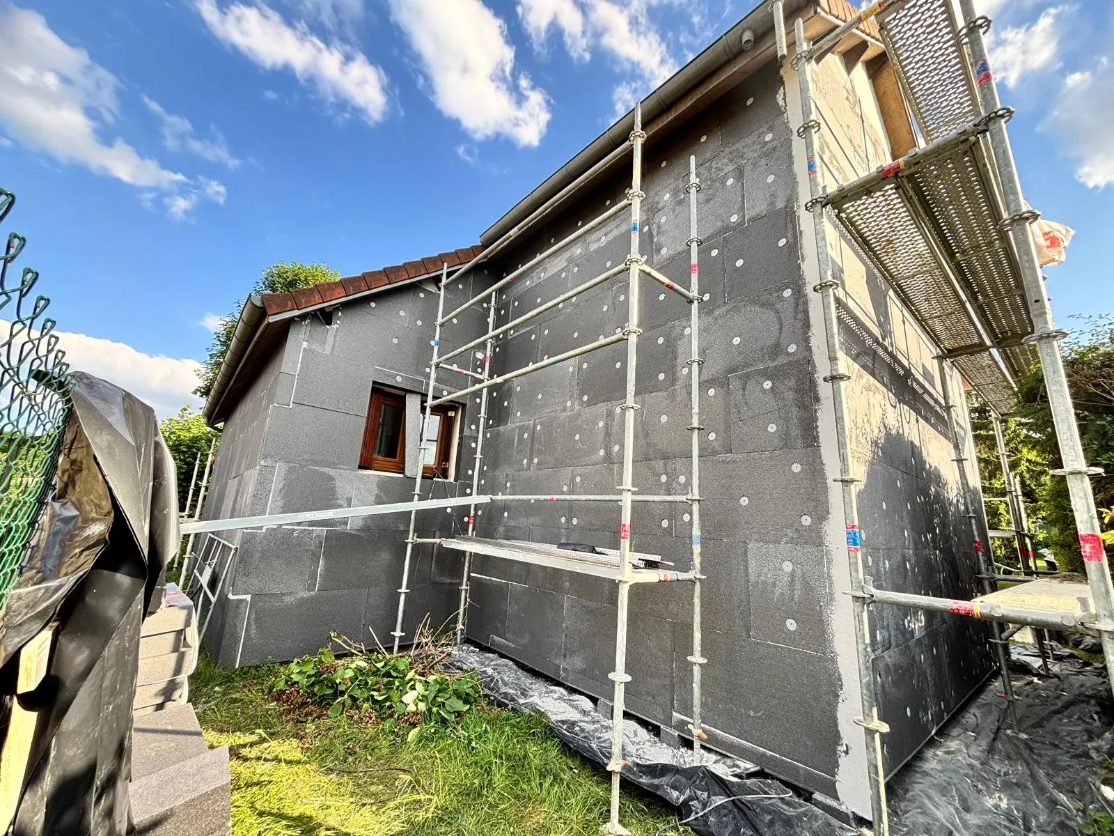 Isolation extérieure : pignon et façade bardés d'isolant en plein soleil