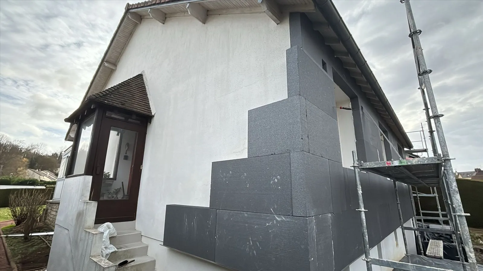 Isolation extérieure : pose en cours - panneaux isolants gris sur pignon blanc