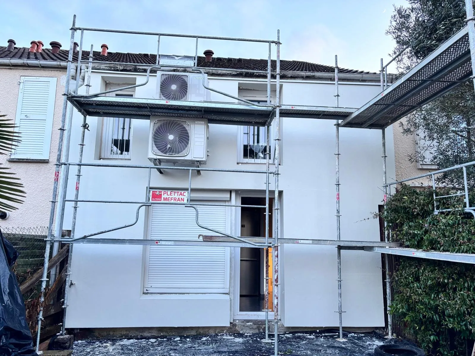 Isolation extérieure : façade entièrement isolée sous échafaudage avec groupes de climatisation
