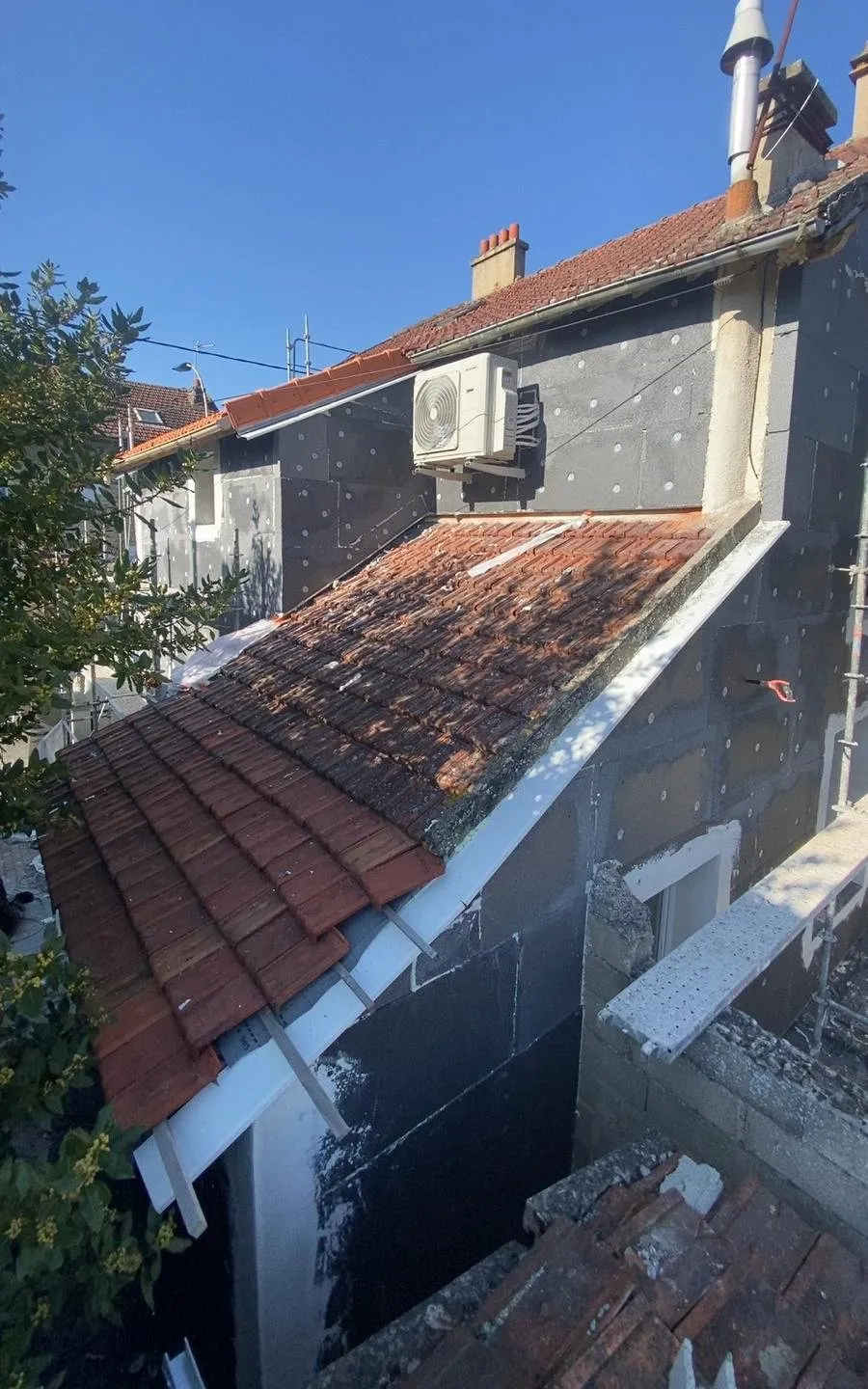 Isolation extérieure : mur isolé au-dessus d'une toiture tuiles