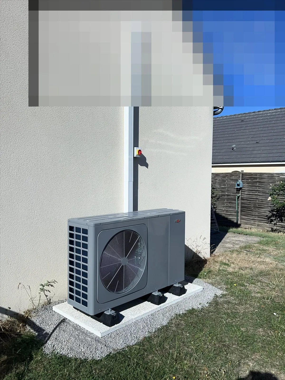 Pompe à chaleur : groupe extérieur sur socle béton le long du pignon