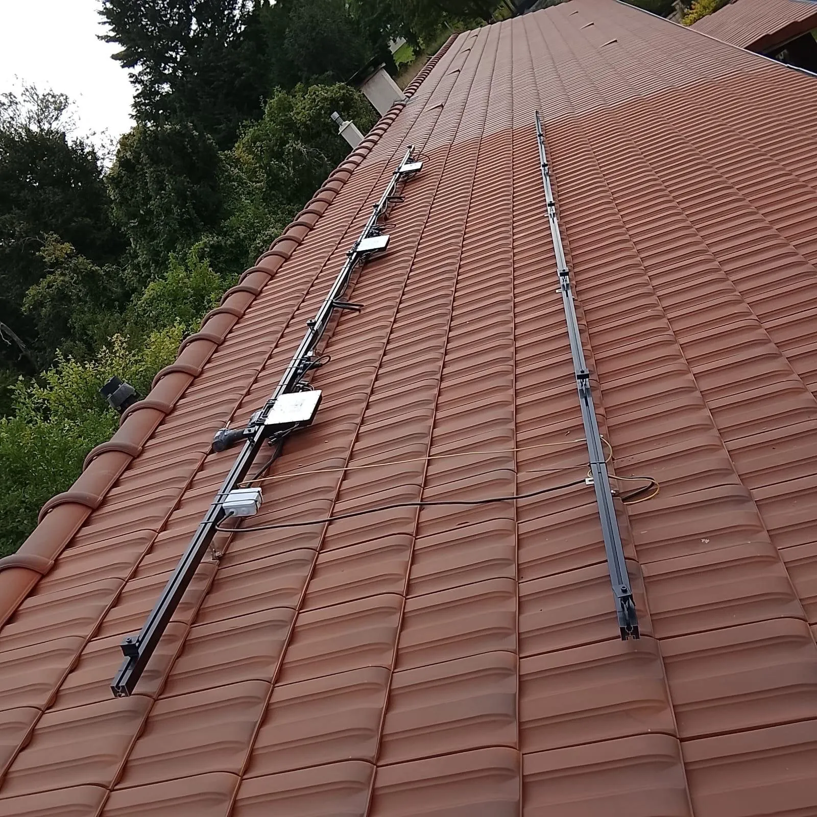 Panneaux solaires : rails de fixation sur toiture tuiles avant pose des panneaux